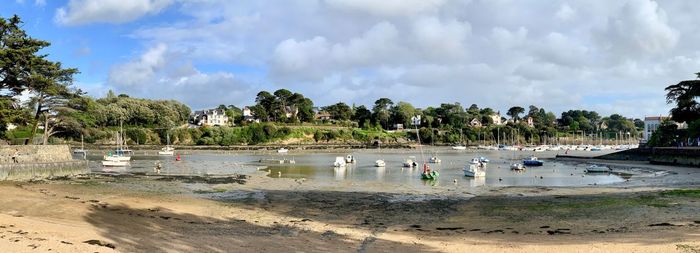 Panoramic view of people on beach against sky