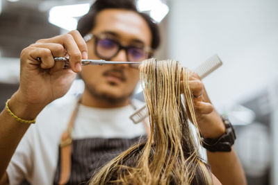 Midsection of young woman applying make-up brushes