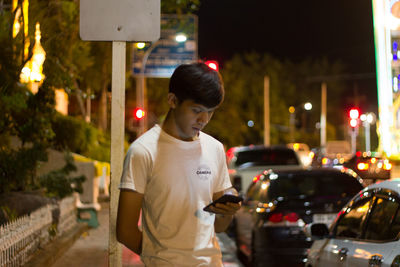 Man standing on street at night