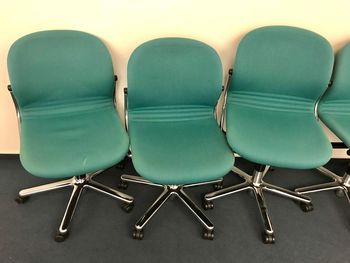 Close-up of chairs on floor against wall