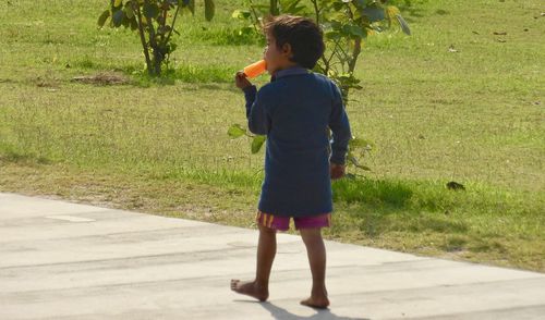 Rear view of woman standing on grass