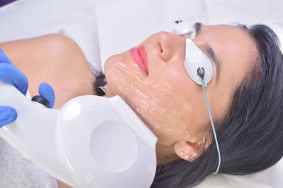 Close-up of woman removing hair with medical laser at spa