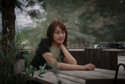 Portrait of young woman sitting on table