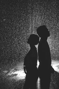 Silhouette couple standing against wall