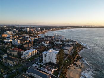 High angle view of townscape by sea against clear sky