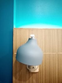 High angle view of lamp on table against blue wall