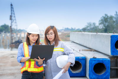 Woman using mobile phone at construction site