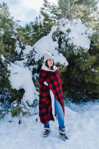 Full length of woman standing on snow covered land outdoors