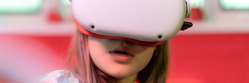 Vr game virtual reality. kid girl gamer playing on futuristic simulation video game in 3d glasses