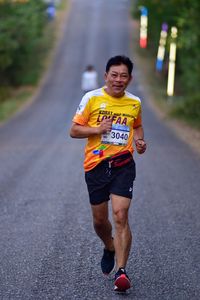 Portrait of man running on road