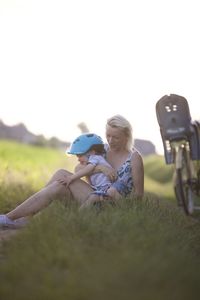 Side view of woman sitting on field