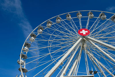 Low angle view of ferris wheel against blue sky