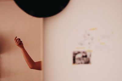 Close-up of woman hand on wall at home