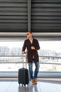 Handsome man looking away while leaning on railing