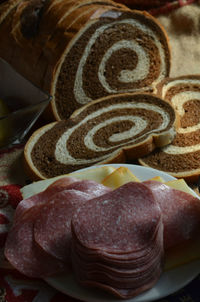 Close-up of marble rye bread by salami on table