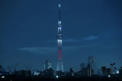 Communications tower in city at night