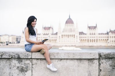 Portrait of young woman sitting on bridge