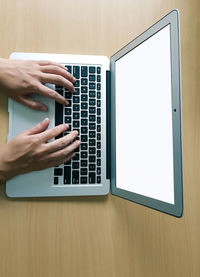 Midsection of man using laptop on table