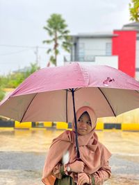 Rear view of hijab girl with umbrella