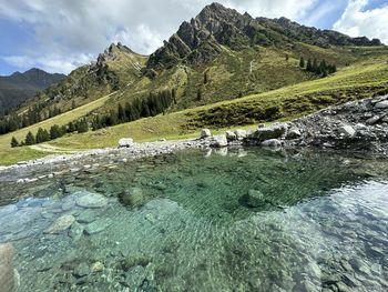 Scenic view of river amidst mountains against sky