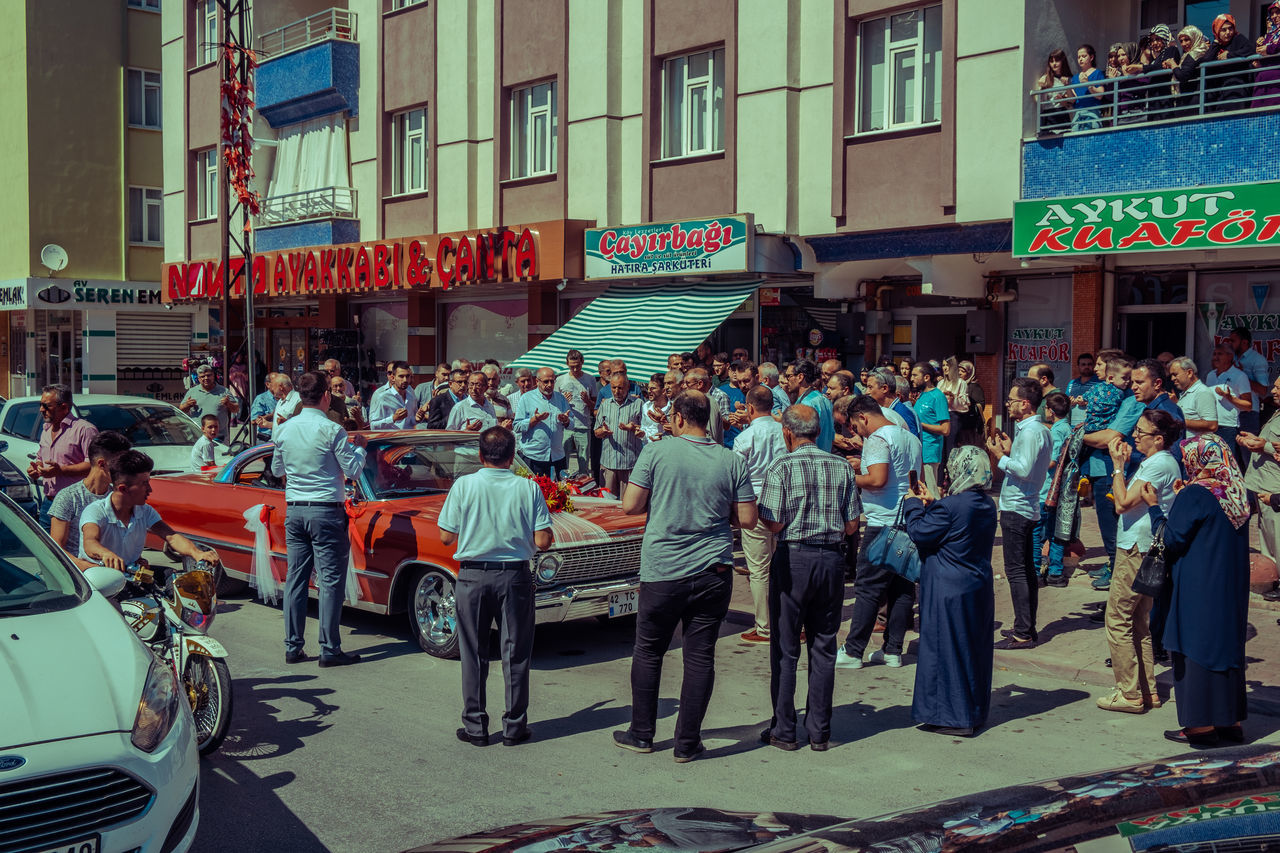 crowd, group of people, large group of people, building exterior, city, architecture, real people, street, built structure, men, women, adult, day, city life, lifestyles, text, city street, outdoors, celebration