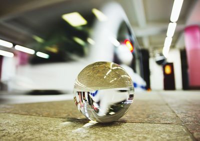 Close-up of crystal ball against train at subway station