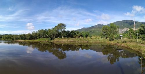 Scenic view of lake by trees against sky