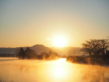 Scenic view of lake against sky during sunset