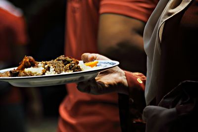 Close-up of man preparing food in plate