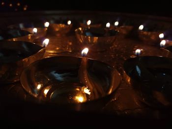 Close-up of lit candles in temple