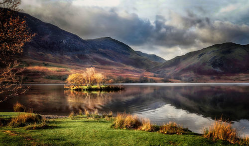 Scenic view of lake by mountains against sky