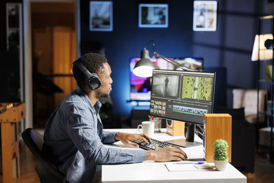 Side view of man using mobile phone in cafe