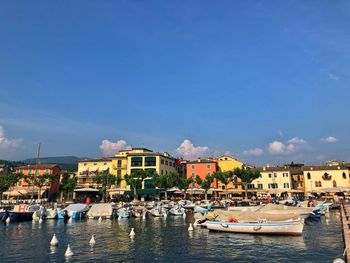 Boats in sea against buildings in city