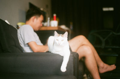 Portrait of young man sitting cat at home