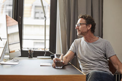 Man sitting at desk looking at computer