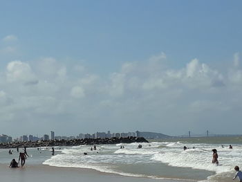 People on beach against sky