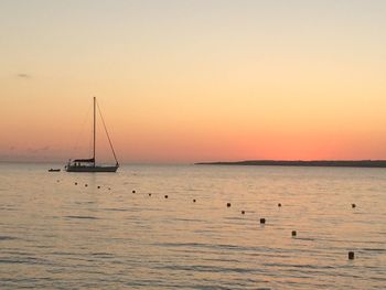 Sailboat sailing on sea against sky during sunset