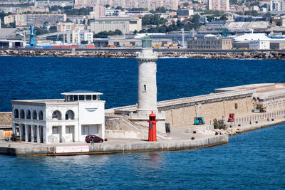 Sailboats in sea against buildings in city