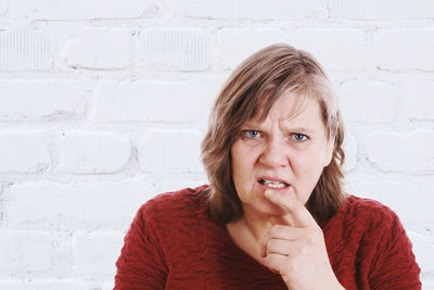 Portrait of young woman against wall