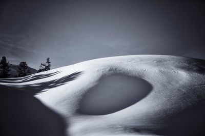 Person on snowcapped mountain against sky