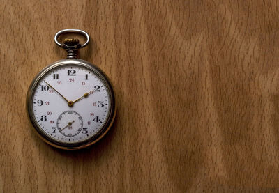 Close-up of watch on wooden table