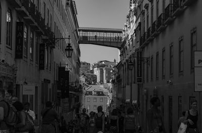 People walking on street in city against sky
