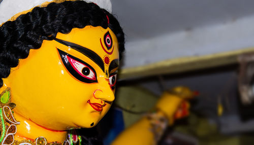 Close-up of yellow durga statue