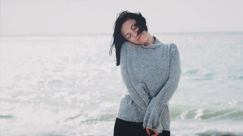 Portrait of woman standing against sea