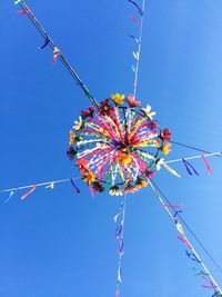 Low angle view of colorful balloons against clear blue sky