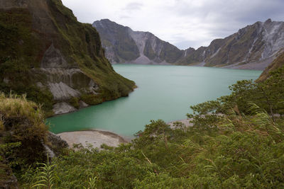 Scenic view of river amidst mountains against sky