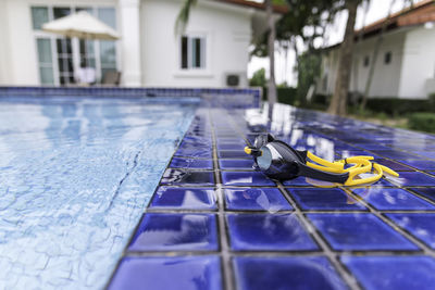 Close-up of swimming goggles by pool