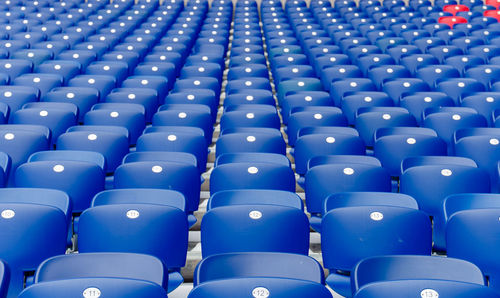 Full frame shot of empty blue chairs at stadium