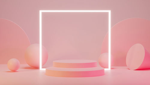 Close-up of pink candle on table against colored background