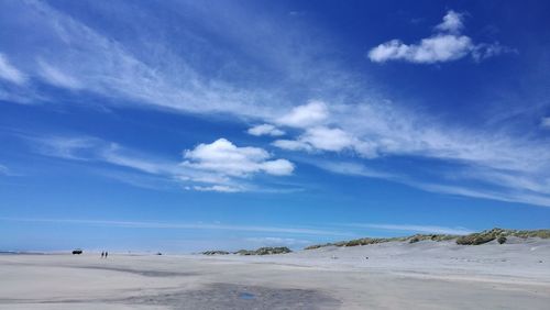 Scenic view of beach against blue sky